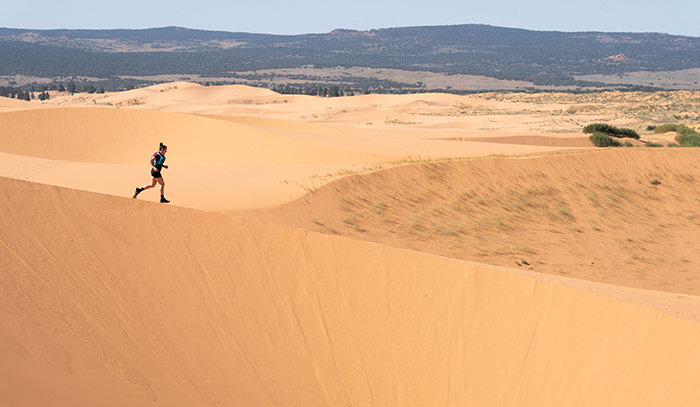 Brooks Ambassador Jacqui Bell runs down a sand dune. Brooks Ambassador Jacqui Bell runs down a sand dune.